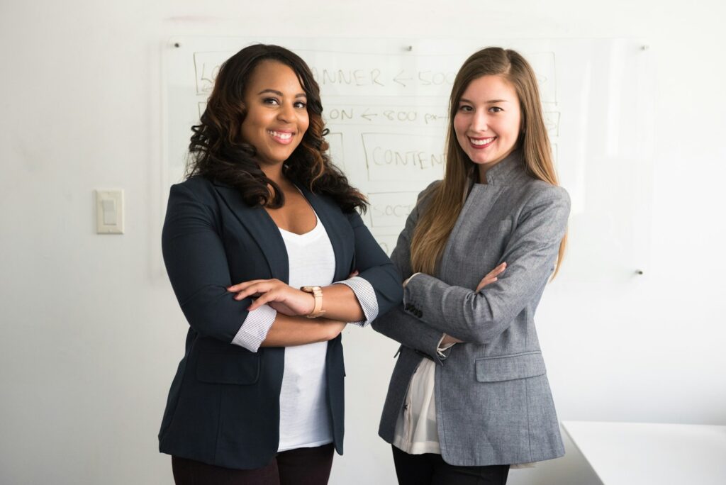 two women in suits standing beside wall representing the power of networking for paraeducators 